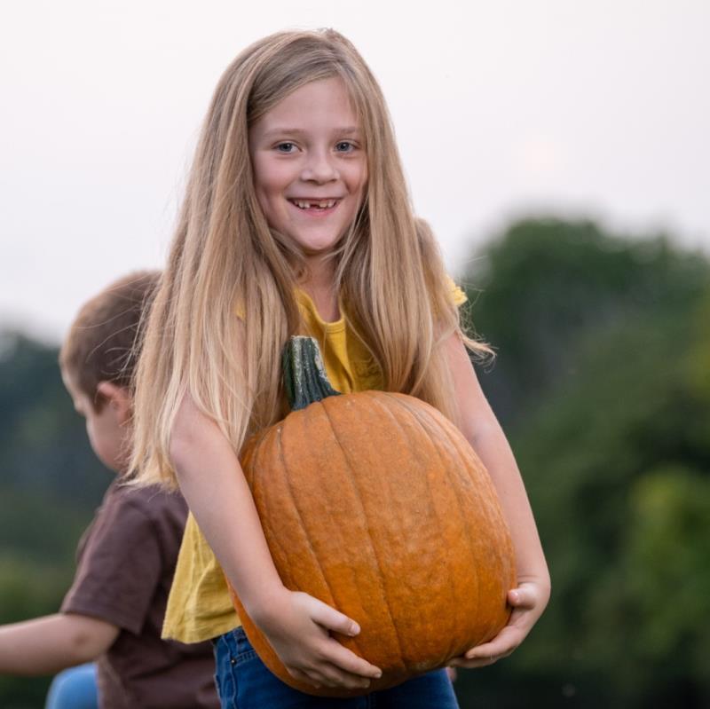 girl holding a pumpkin